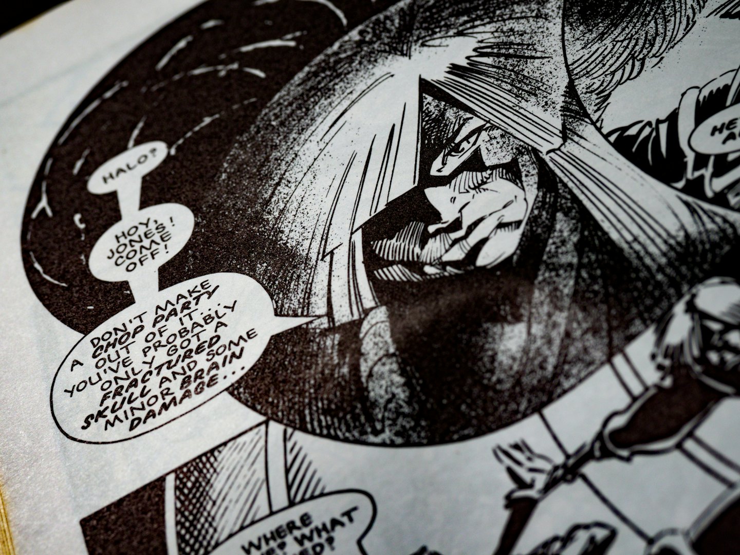 Close-up of an open comic book page with ink illustrations.