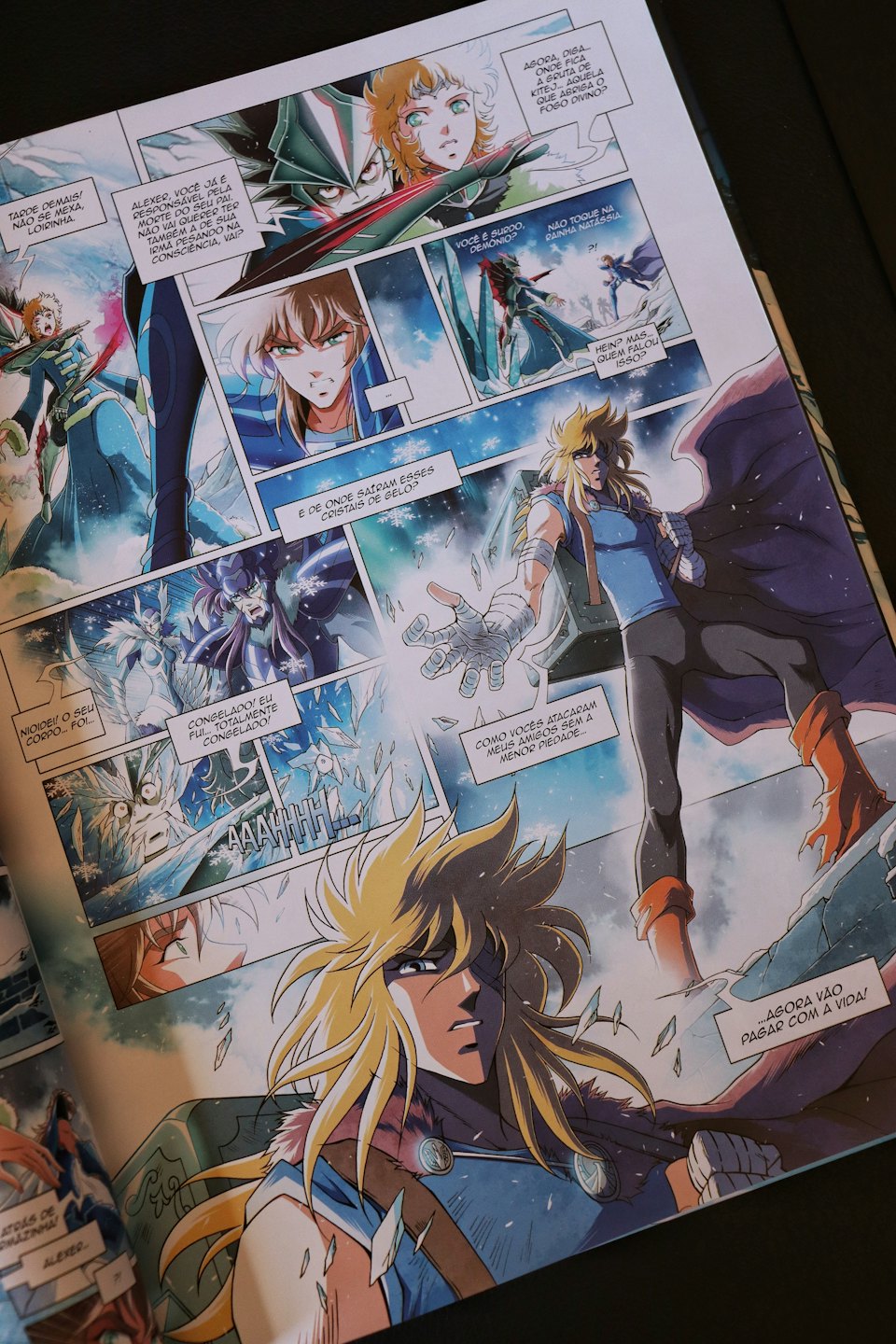 Open comic book pages showing colorful manga action illustrations.